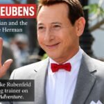 Paul Reubens as Pee-wee Herman in a gray suit and red bow tie, featured in an article about his brother Luke Rubenfeld and his animal-training work.